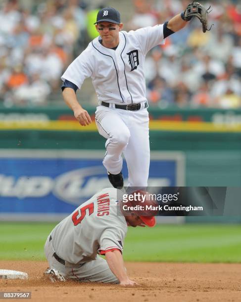 Adam Everett of the Detroit Tigers leaps into the air to avoid the sliding Jeff Mathis of the Los Angeles Angels of Anaheim during the game at...