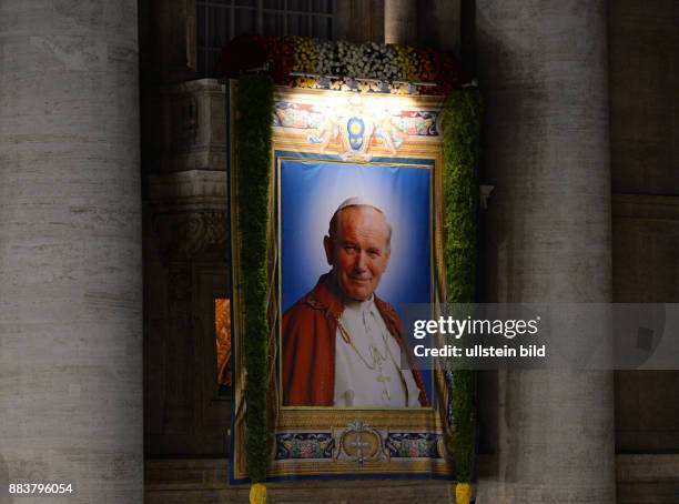 Rom, Vatikan Heiligsprechung Papst Johannes Paul II und Papst Johannes XXIII Ein Bild von Papst Johannes Paul II wird in der Nacht am Petersdom...