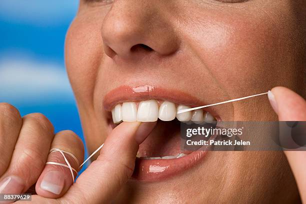 young woman flossing her teeth, close-up - zahnseide stock-fotos und bilder