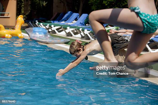 children (10-11) jumping into swimming pool - northern european descent ストックフォトと画像