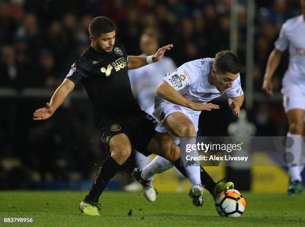 Andy Bond of AFC Fylde is tackled by Sam Morsy of Wigan Athletic during The Emirates FA Cup Second Round between AFC Fylde and Wigan Athletic on...