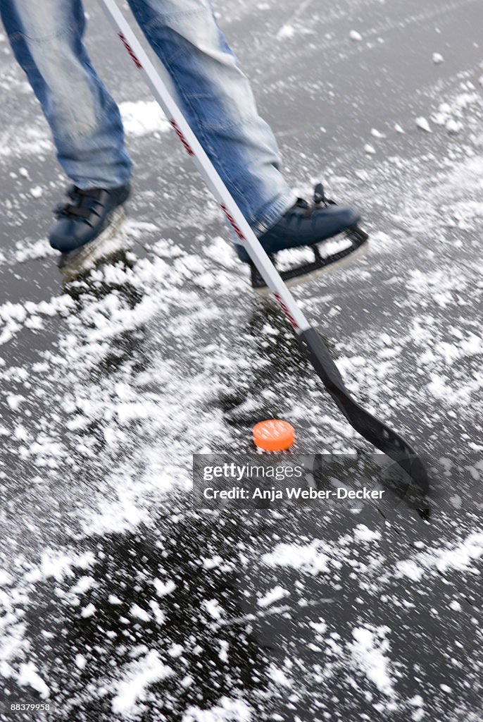 Person playing ice hockey on frozen lake