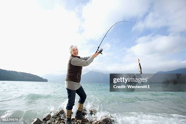 germany, bavaria, walchsensee, senior woman fishing in lake - 死体 女性一人 ストックフォトと画像