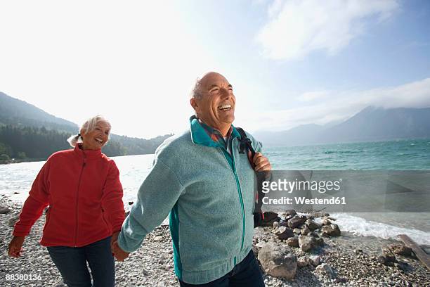 germany, bavaria, walchensee, senior couple hiking on lakeshore - bald man stock pictures, royalty-free photos & images