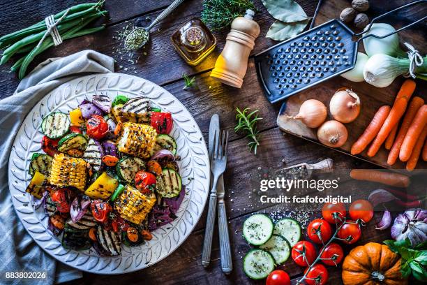 grilled vegetables plate shot from above on rustic wooden kitchen table - roasted pepper stock pictures, royalty-free photos & images