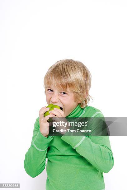little boy (10-11) biting into apple - child holding apples stockfoto's en -beelden