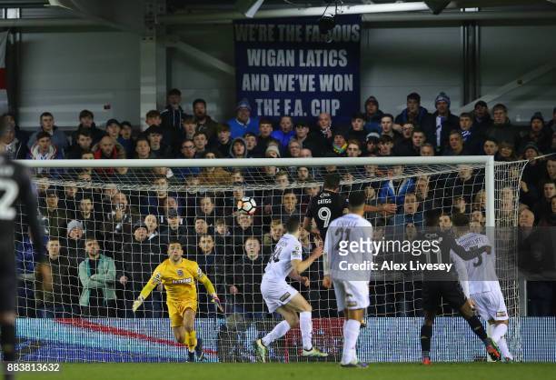 Will Grigg of Wigan Athletic scores the opening goal past Jay Lynch of AFC Fylde with a header during The Emirates FA Cup Second Round between AFC...