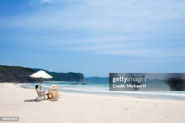 man and woman who enjoys vacation on beach - japanese couple beach stock-fotos und bilder