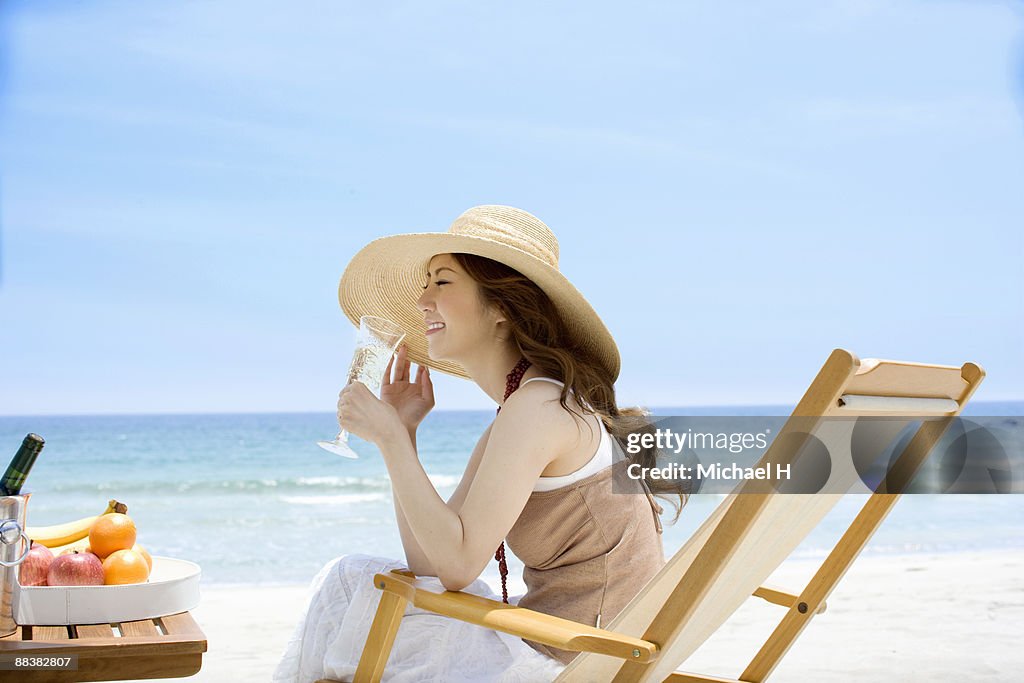 Woman who drinks champagne on beach