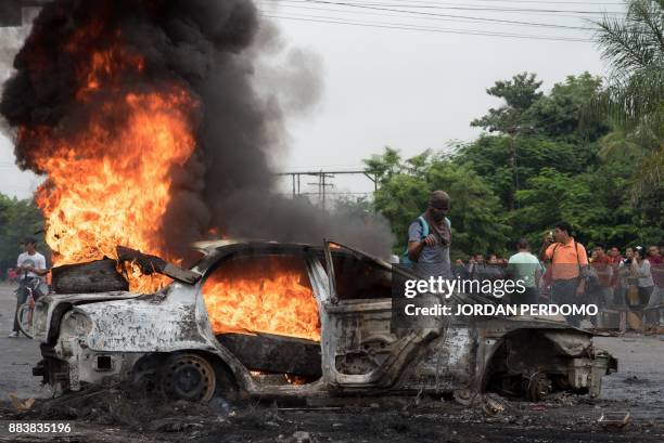 Car set on fire by supporters of Honduran presidential candidate for the Opposition Alliance against the Dictatorship coalition Salvador Nasralla...