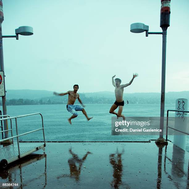 two jumping into lake - zurich stock-fotos und bilder