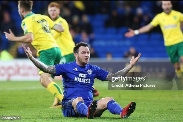 Angus Gunn of Norwich City brings Lee Tomlin of Cardiff City to the ground, seen complaining to the linesman before being awarded a penalty during...