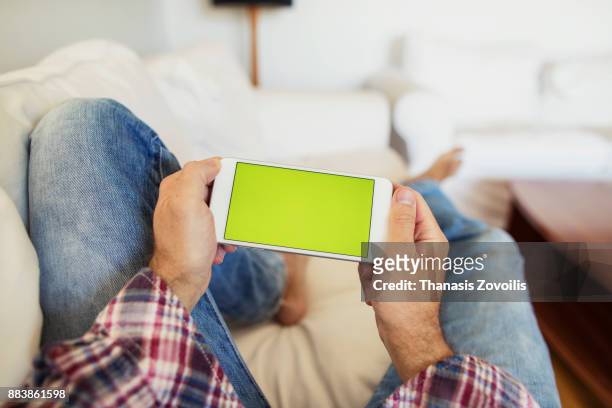 man holding a smart phone - horizontal stock-fotos und bilder
