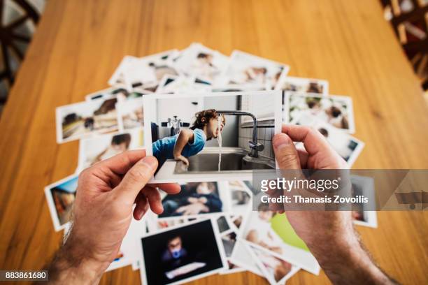 man holding a photo - nostalgie photos et images de collection