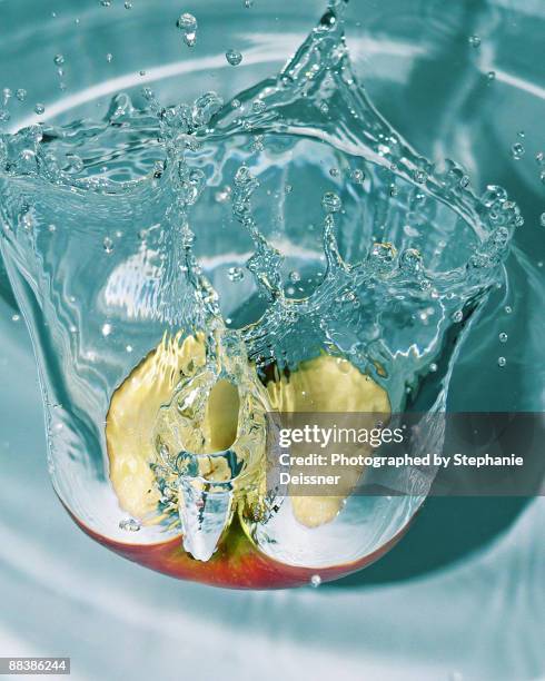 red half apple splashing in water  - apple water splashing stock pictures, royalty-free photos & images