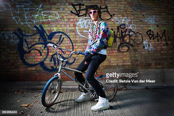 young man sitting on bike. - sunny side stock pictures, royalty-free photos & images