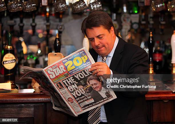 Leader of the British National Party, Nick Griffin MEP reads a newspaper reporting the egg throwing incident before giving a media conference in the...