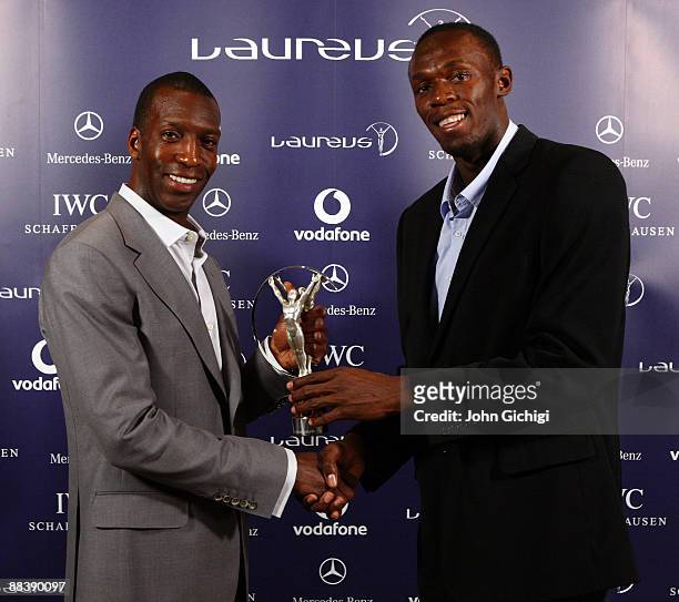 Usain Bolt world record holder for 100m and 200m, receives the Laureus World Sportsman of the year award from Academy member Michael Johnson, during...