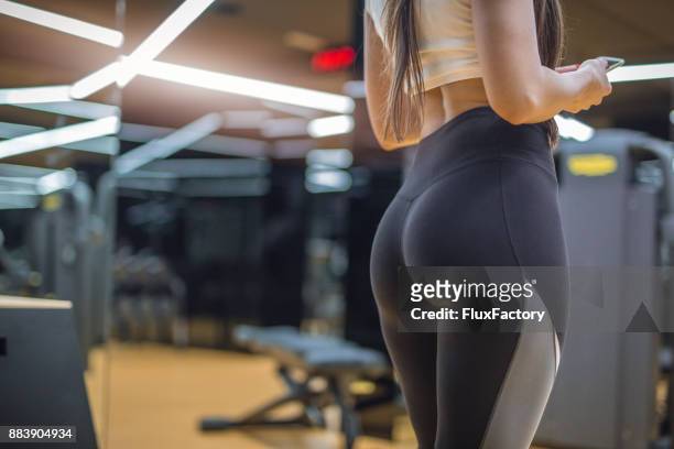 mujer atractiva en un gimnasio en un pantalon caliente - gluteos fotografías e imágenes de stock