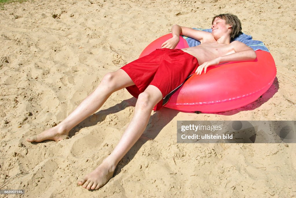 Bot Sunbaking boy sunbathing on a rubber tyre News Photo - Getty Images