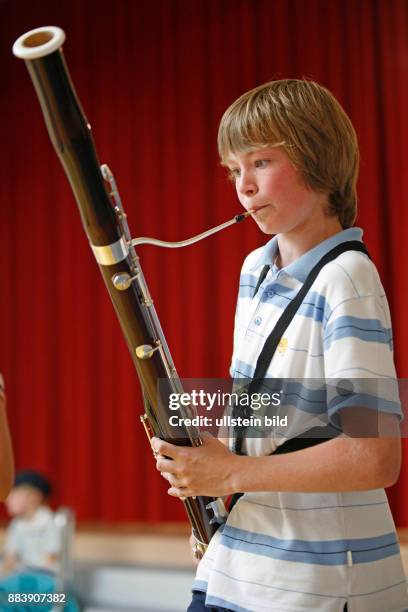 Boy playing the bassoon / boys / child / children / childhood / musical instrument