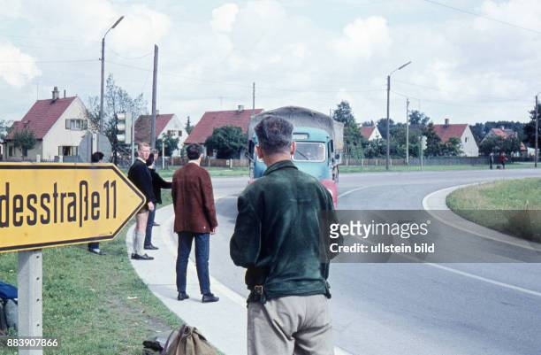 Ca. 1960, Junge Männer warten auf eine Mitfahrgelegenheit