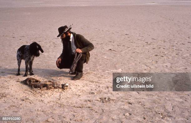 Deutschland, ca.1980, Jäger mit seinem Hund auf Amrum