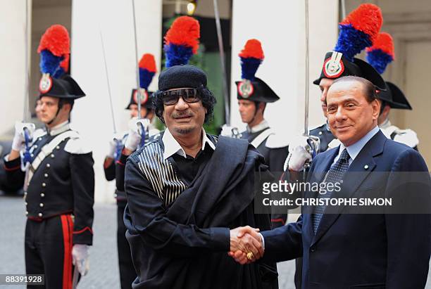 Libya's leader Moamer Kadhafi is greeted by Italian Prime Minister Silvio Berlusconi upon arrival for their meeting on June 10, 2009 at the Palazzo...