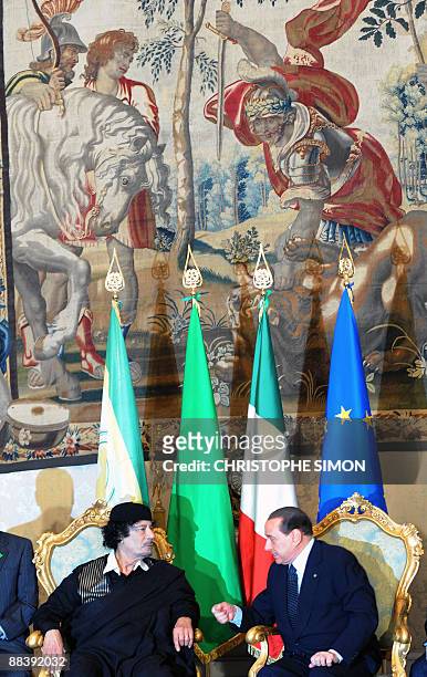 Libya's leader Moamer Kadhafi flistens to Italian Prime Minister Silvio Berlusconi during their meeting on June 10, 2009 at the Palazzo Chigi in...