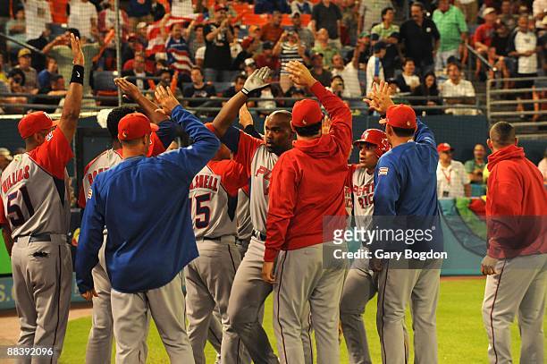 Puerto Rico's Carlos Delgado and Ivan "Pudge" Rodriguez celebrate with their team after they both score during the Pool 2 Game 5, of the second round...
