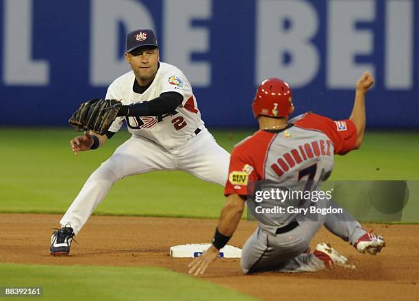 Team USA's Derek Jeter makes a play as Puerto Rico's Ivan "Pudge" Rodriguez slides into second during the Pool 2 Game 5, of the second round of the...