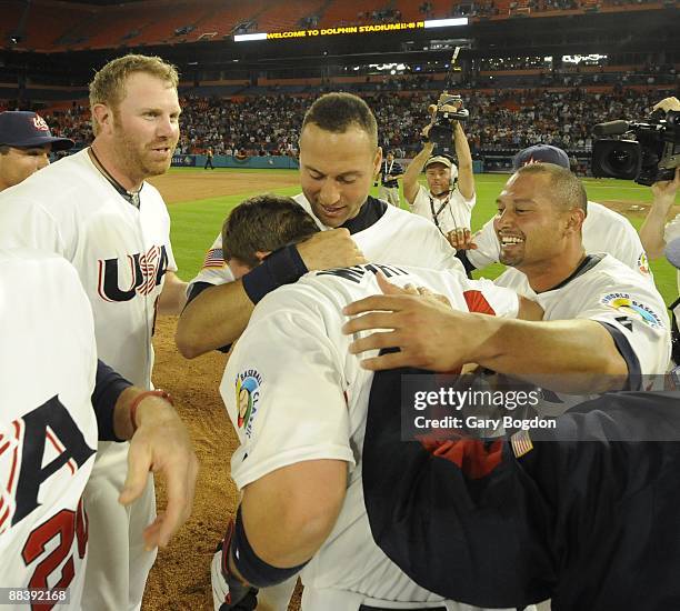 Team USA's David Wright is hugged by teammates Adam Dunn, Derek Jeter and Shane Victorino on the field in celebration during the Pool 2 Game 5, of...