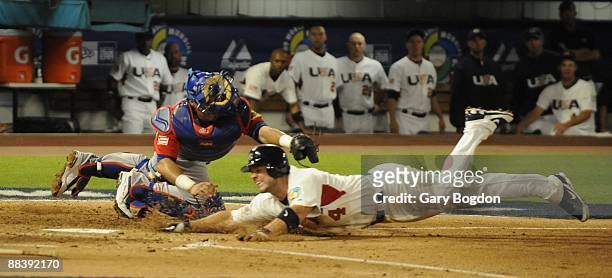 Team USA's David Wright slides safely into homeplate and scores as Puerto Rico catcher Geovany Soto tries in vain to make the tag during the Pool 2...