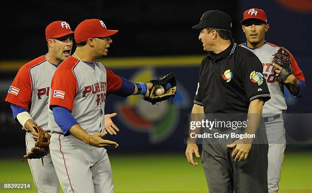 Team Puerto Rico players argue with the umpires over a controversial play that sent Shane Victorino to third base during the Pool 2 Game 5, of the...