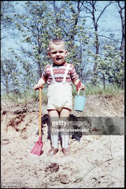 Aufnahme ca. 1950, Kindheit, Kind spielt im Sand mit Eimer und Schaufel