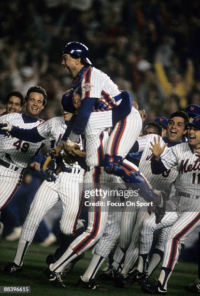 Catcher Cary Carter jumps into the arms of Pitcher Jesse Orosco of the New York Mets with jubilation after Orosco struck out Marty Berrett of the...