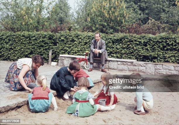 Aufnahme ca. 1950, Kindheit, Kinder spielen im Buddelkasten auf dem Spielplatz