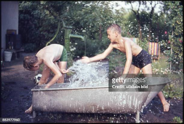 Aufnahme ca. 1950, Kindheit, Jungen spritzen im Garten mit Wasser