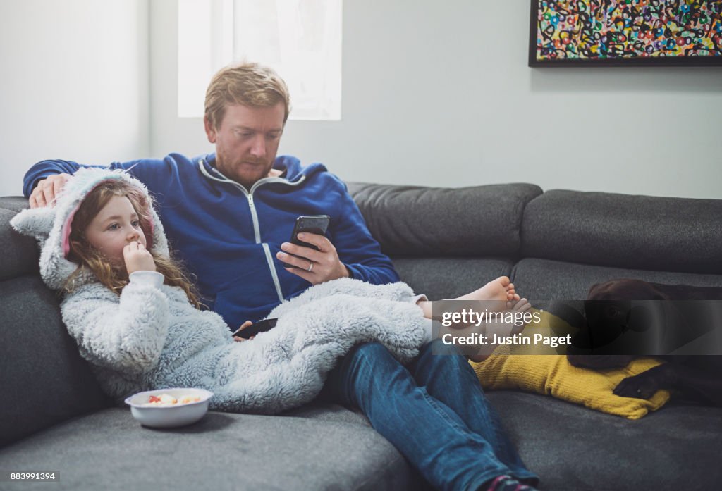 Father and daughter relaxing on the sofa