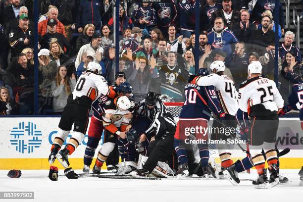 Linesmen Mark Shewchyk and Pierre Racicot break up a fight during the second period of a game between the Columbus Blue Jackets and the Anaheim Ducks...