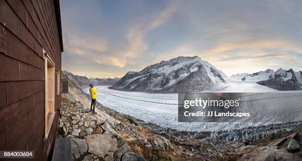 hiker looking at glacier at sunset, aletsch glacier, switzerland - aletsch glacier stock pictures, royalty-free photos & images