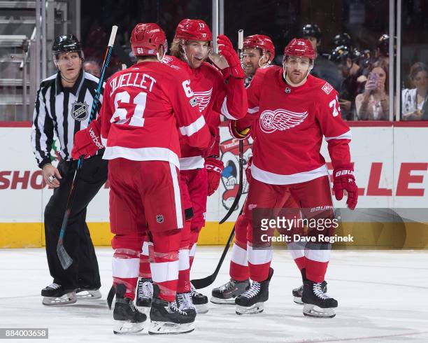 David Booth of the Detroit Red Wings celebrates his first period goal with teammates Xavier Ouellet and Scott Wilson during an NHL game against the...