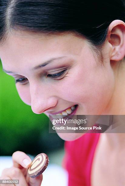 woman eating biscuit - mangiare stockfoto's en -beelden