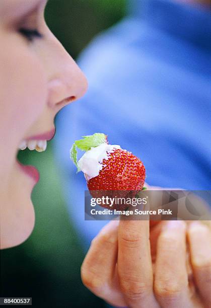 woman eating strawberry - mangiare fotografías e imágenes de stock