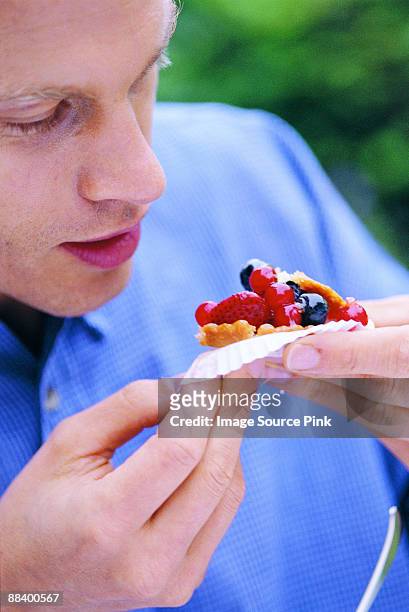 man eating tartlet - mangiare stock pictures, royalty-free photos & images
