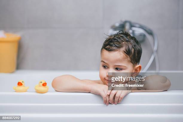 浴槽の中の少年 - おもちゃのアヒル ストックフォトと画像