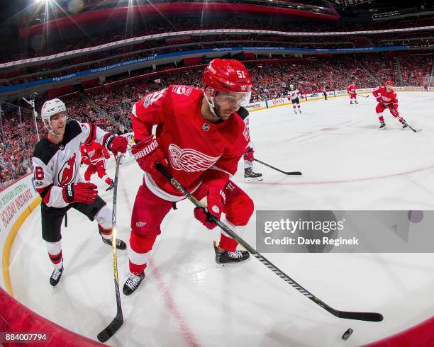 Frans Nielsen of the Detroit Red Wings battles in the corner for the puck with Steven Santini of the New Jersey Devils during an NHL game at Little...