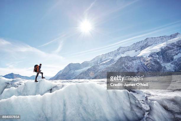 hiker on glacier with distant mountains, aletsch glacier, switzerland - aletsch glacier stock pictures, royalty-free photos & images