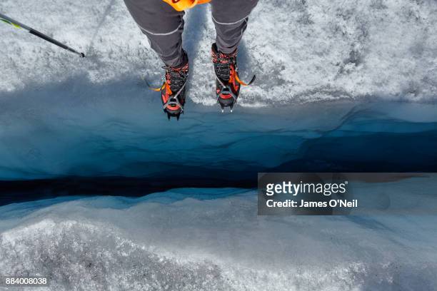standing on the edge of to a glacial crevas. aletsch glacier, switzerland - looking down at feet stock pictures, royalty-free photos & images