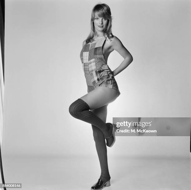 Fashion model Sally Bodington wearing a patched playsuit, over the knee socks and clogs, UK, 19th March 1971.